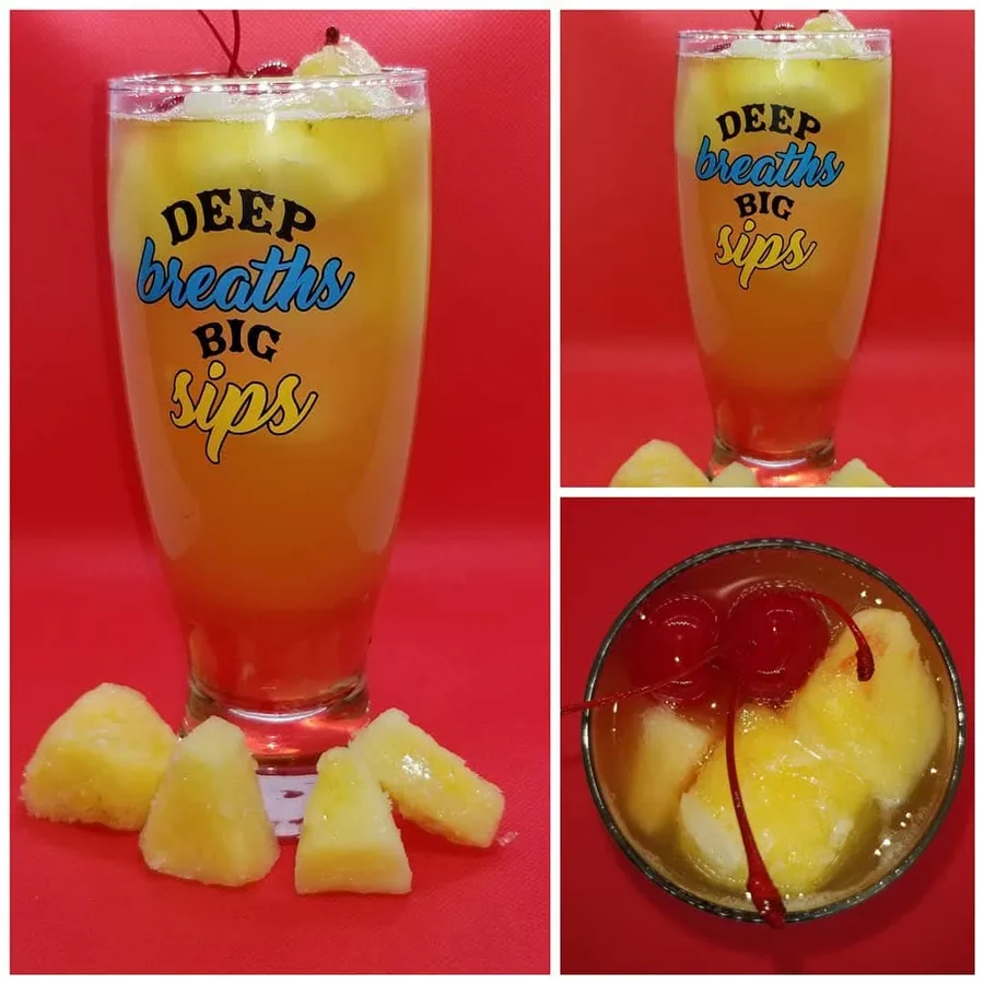 Pineapple Whiskey Sour shown from the side and above with pineapple and cherries